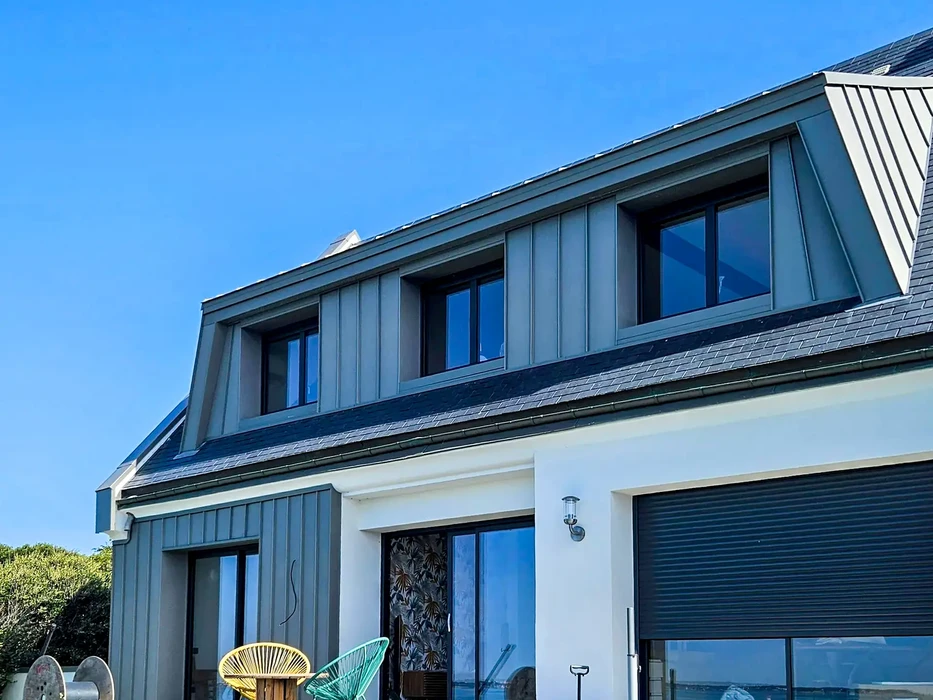 Maison contemporaine à étage avec toiture mansardée et bardage métallique zinc anthracite