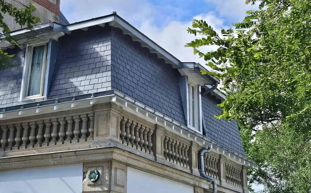 Façade extérieure d'une maison bourgeoise avec balustrade en pierre sculptée et balcon décoratif