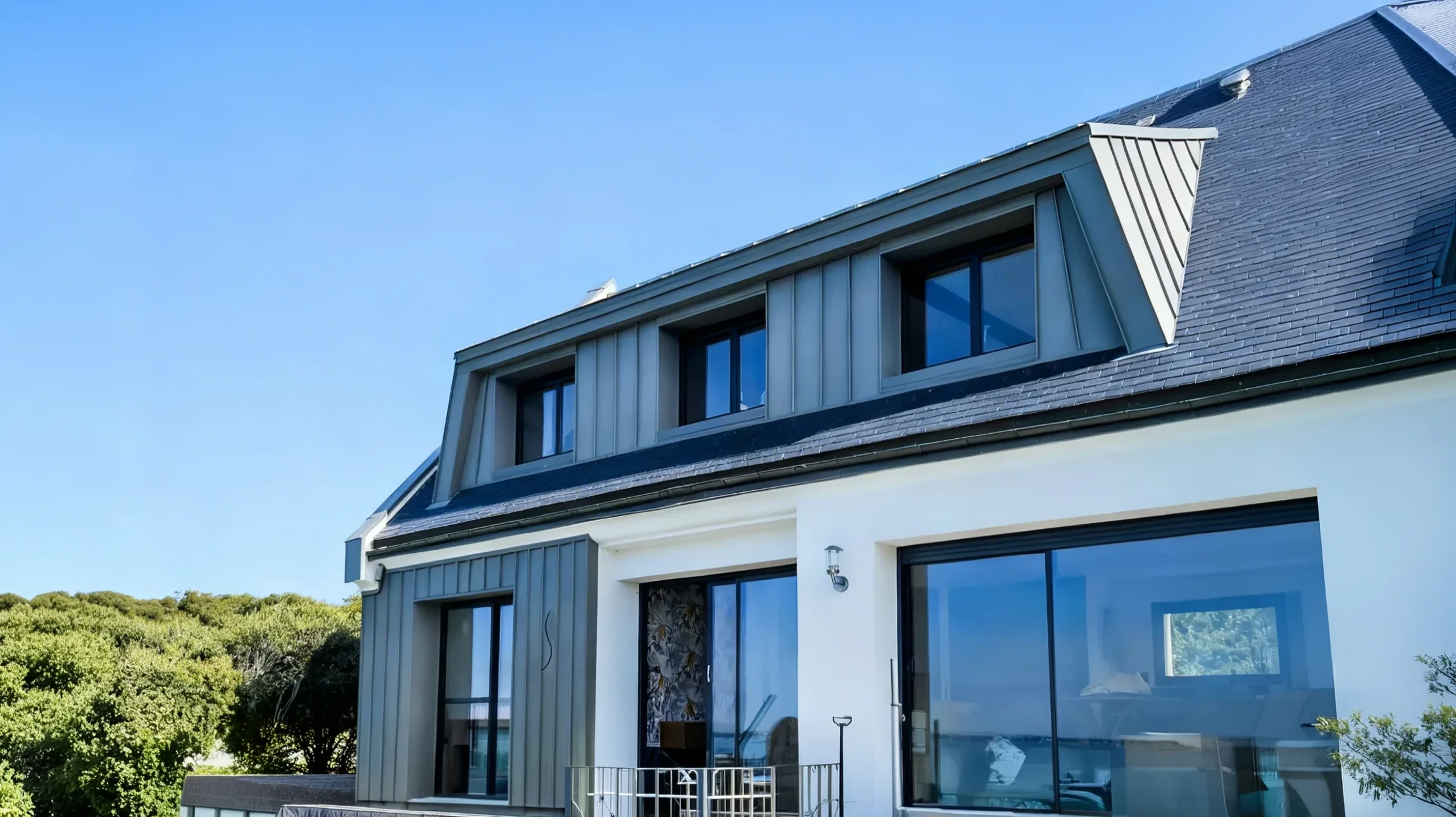Façade moderne d'une maison contemporaine avec porche couvert, pilier en pierre naturelle et structure métallique