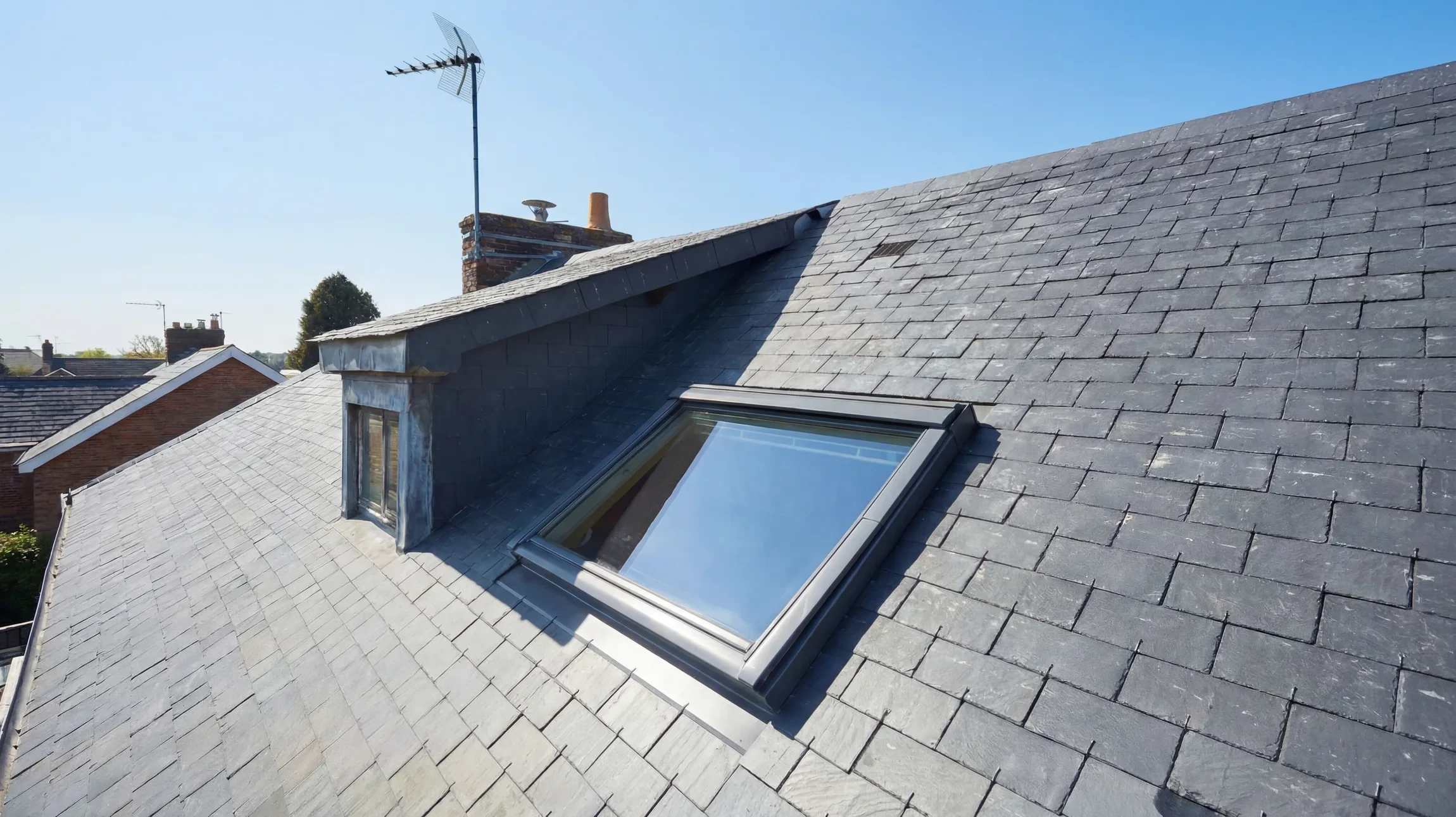 Vue d'un coin d'une maison vintage couleur tan avec garniture blanche et espaceurs de fenêtres en bois noir