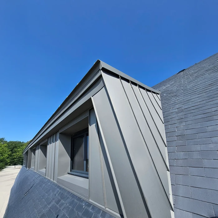 Chantier de rénovation de toiture en ardoises avec charpente bois apparente