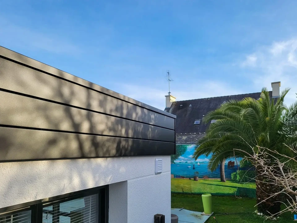 Chantier de rénovation extérieure d'une maison avec bardage vinyl blanc