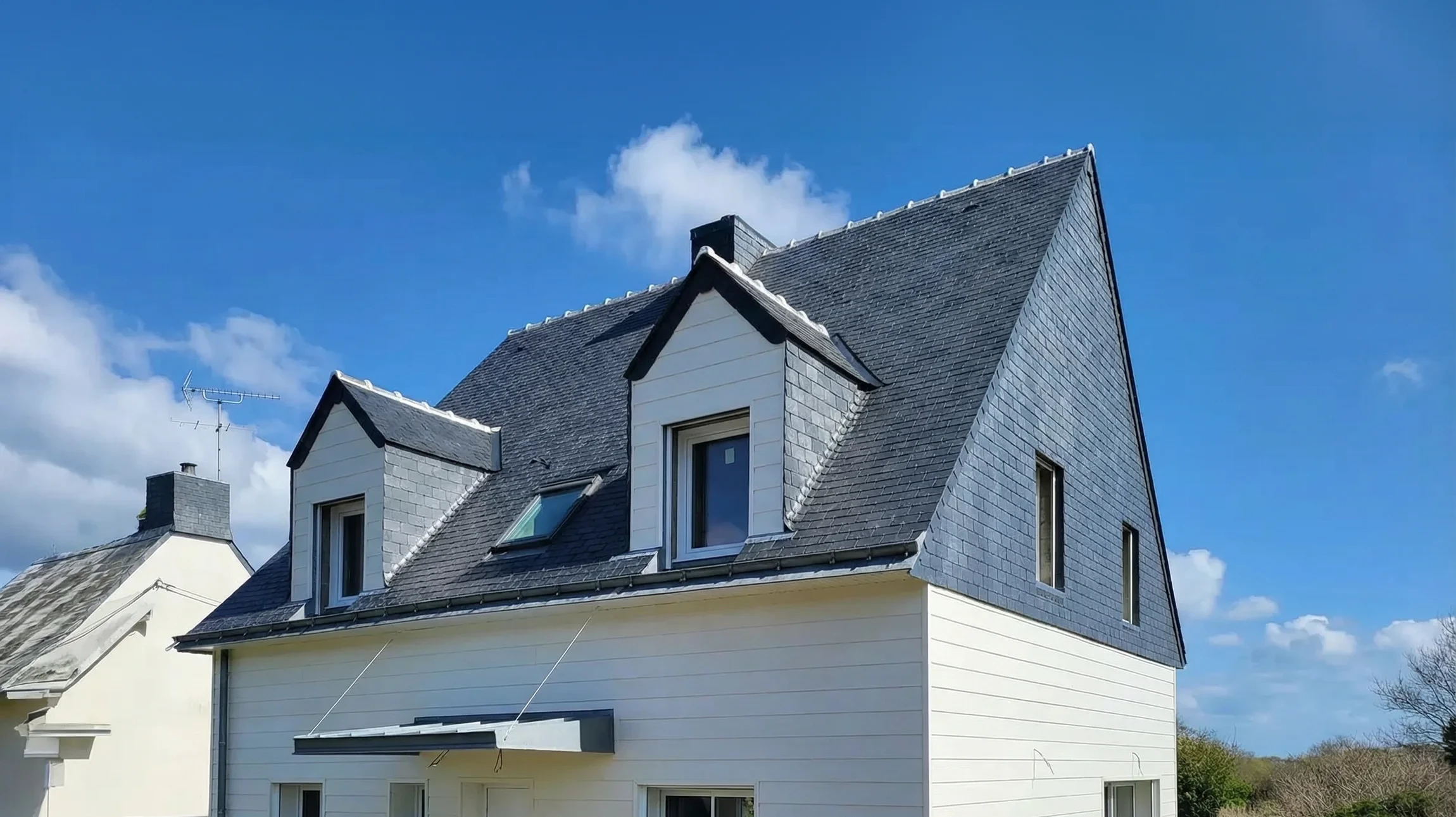Toiture en tuiles canal rouges sous ciel bleu avec soleil couchant