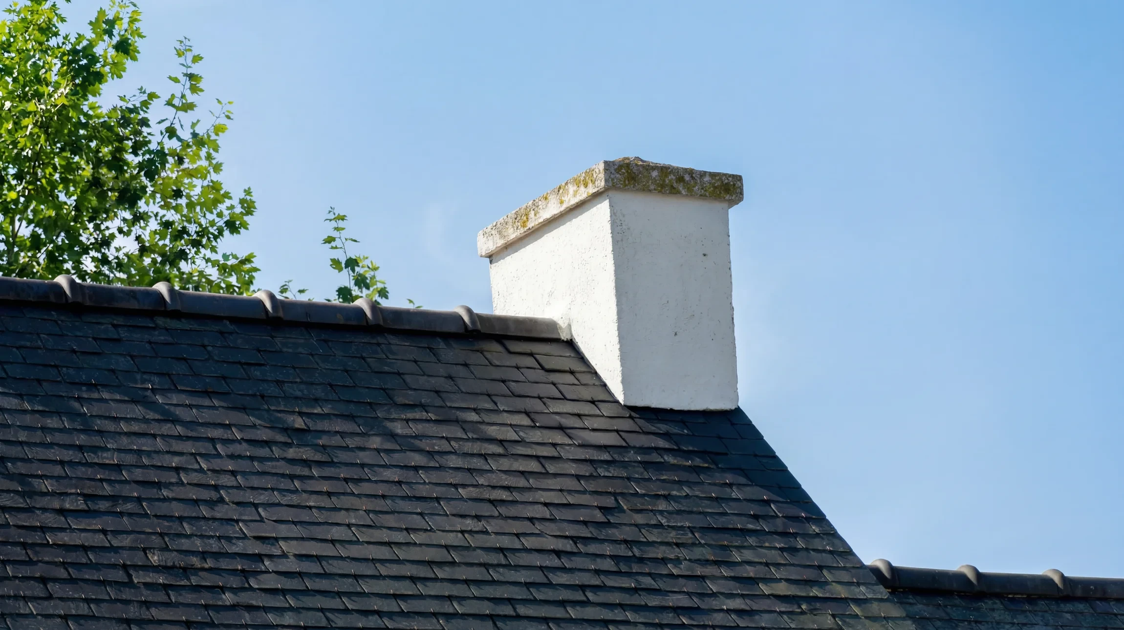 Chantier de construction extérieur avec charpente en bois brut en cours d'assemblage sous ciel bleu nuageux